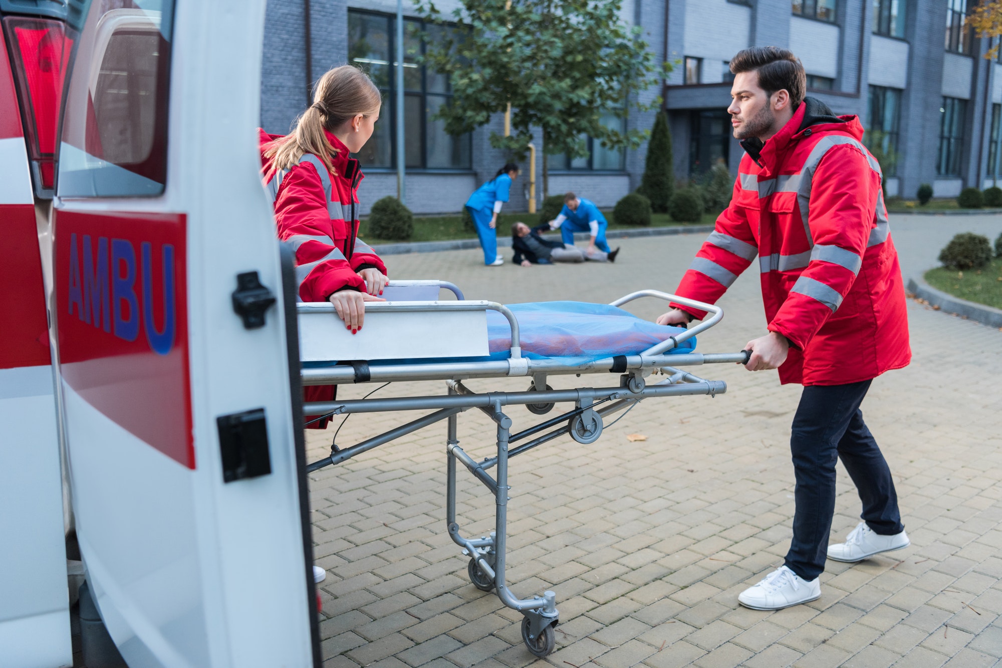 doctors taking ambulance stretcher to help wounded man