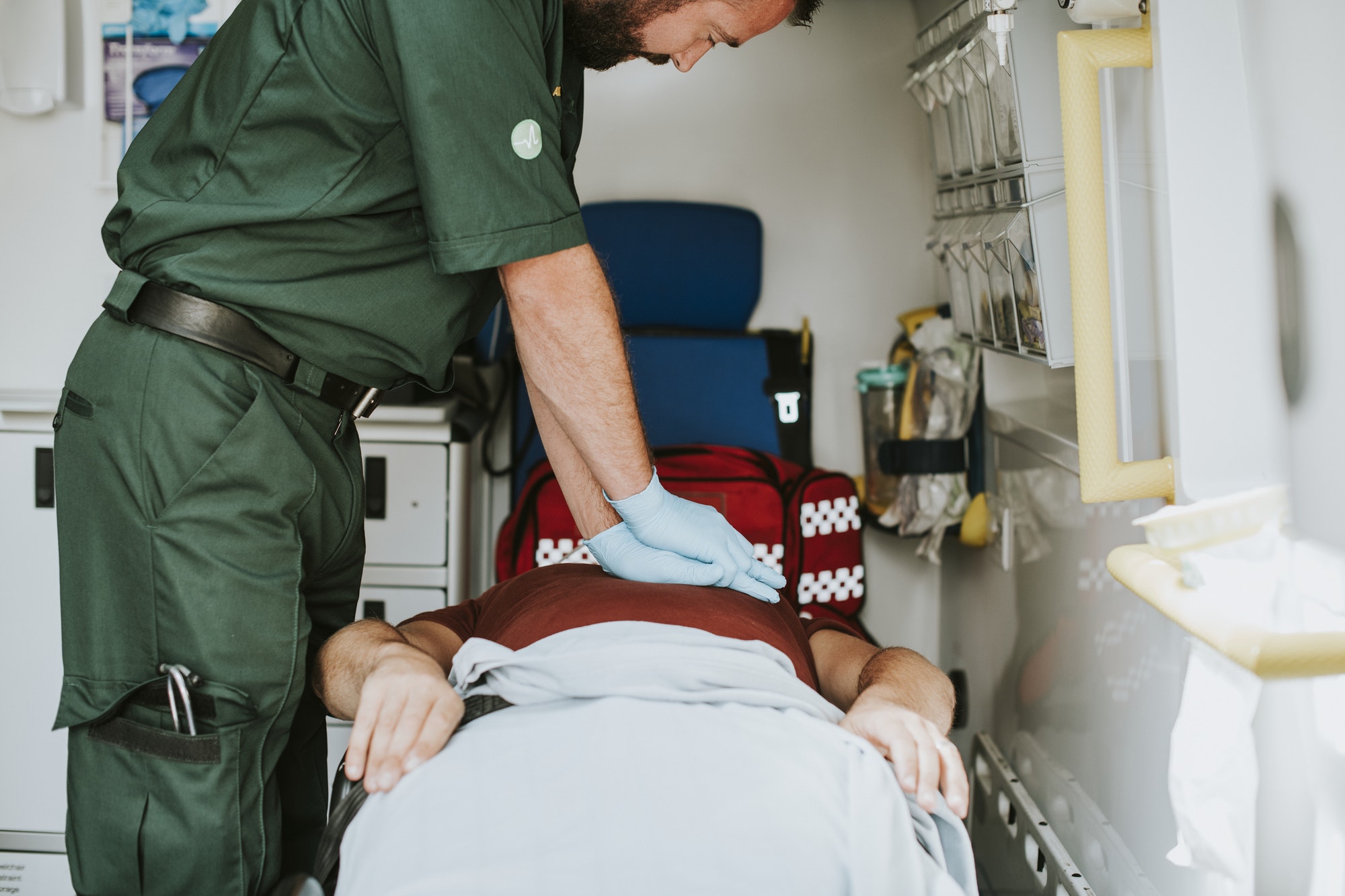 Paramedic resuscitating a patient in an ambulance